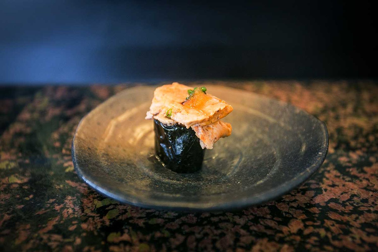 Gunkan Maki Sushi, bestehend aus Reis und Nori, belegt mit einer Schicht Fischleber, serviert auf einem Teller