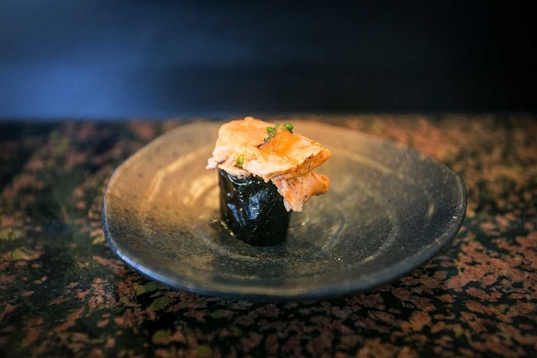 Gunkan Maki Sushi made of rice and nori, topped with a layer of fish liver, served on a plate