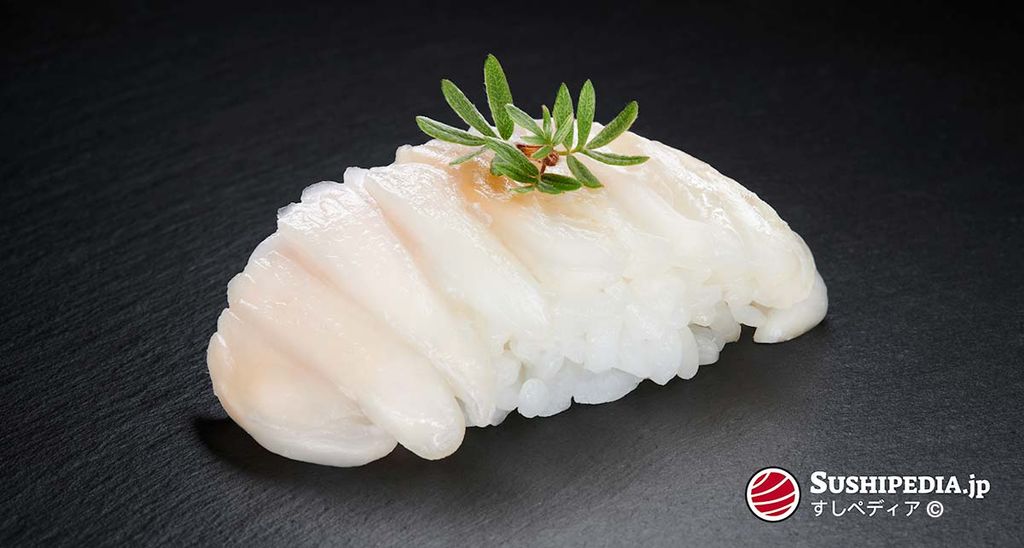 Engawa Sushi, elegant angerichtet mit einem Zweig grünem Shiso auf schwarzem Hintergrund.