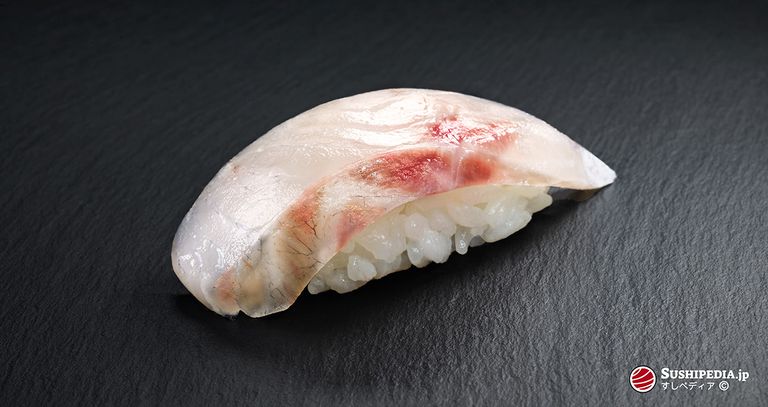 Foto eines frisch zu bereiteten Sushi (nigiri sushi) mit der Zutat, die den japanischen Namen Suzuki trägt.