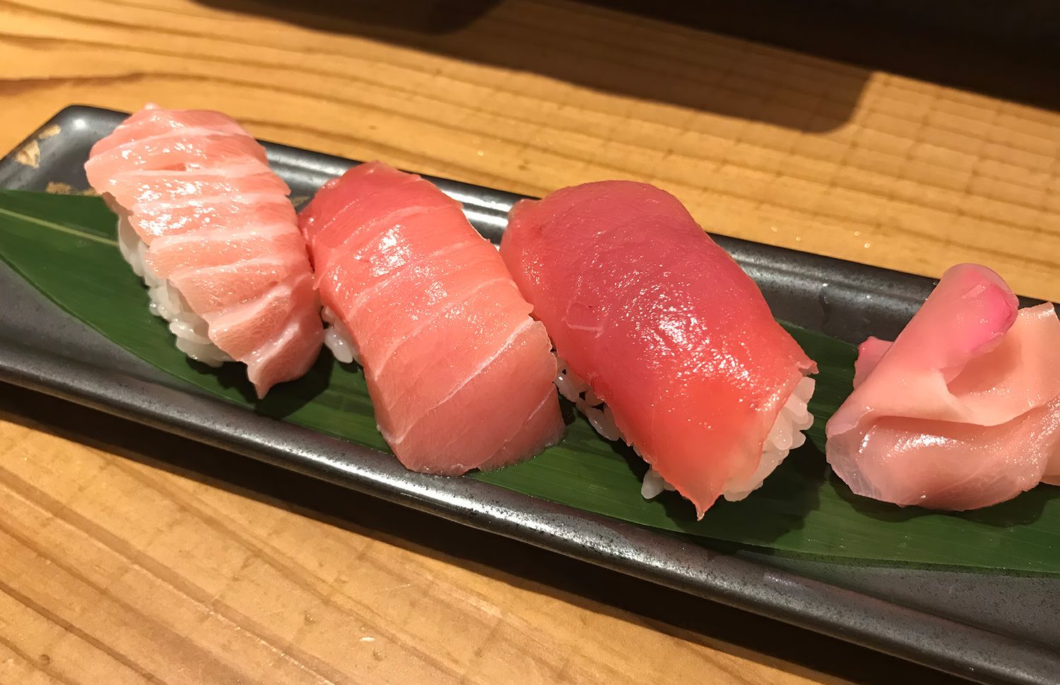 Eine Reihe von Thunfischfleisch Sushi, bestehend aus je einem Stück besonders fettem, halbfettem und magerem Fleisch.